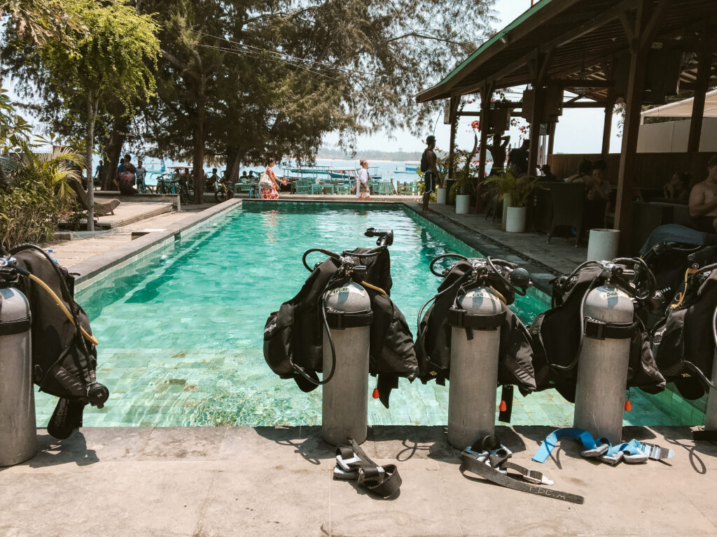 scuba tanks in front of a pool near a beach