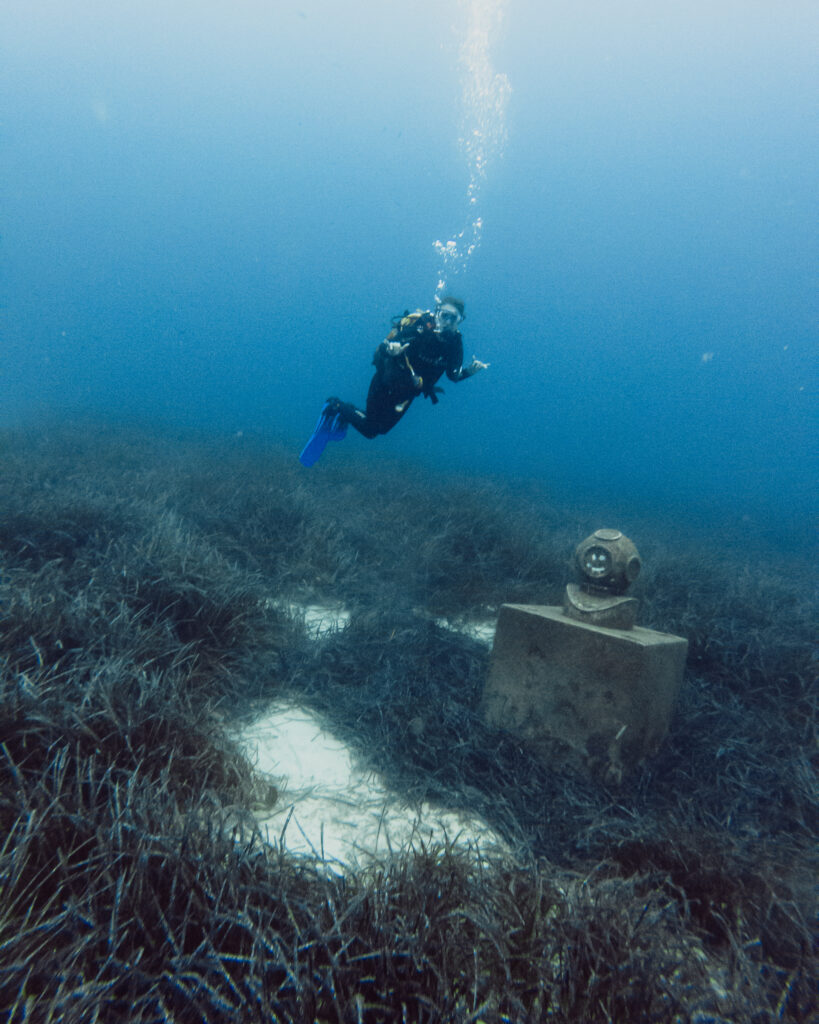 scuba diver with diving bell statue underwater smiley face seagrass