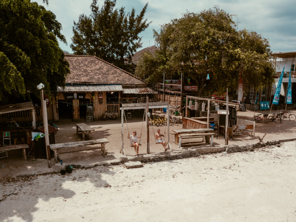 couple on swings on gili trawangan beach