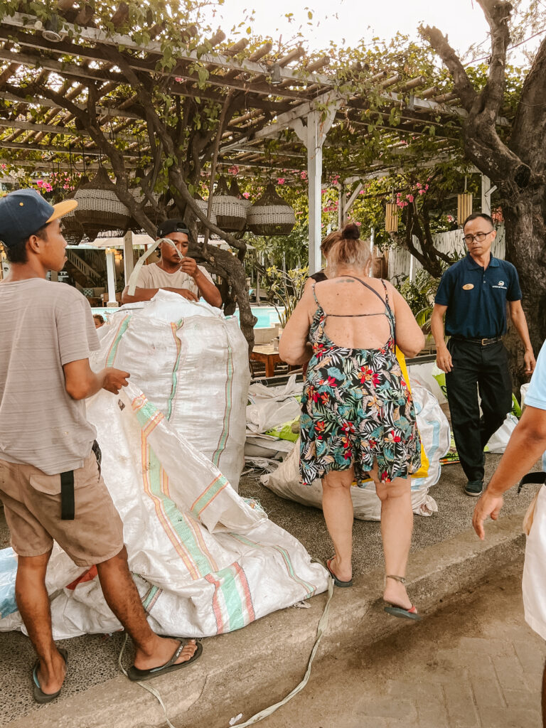 a debris free friday beach clean on gili trawangan with participants and white trash bags