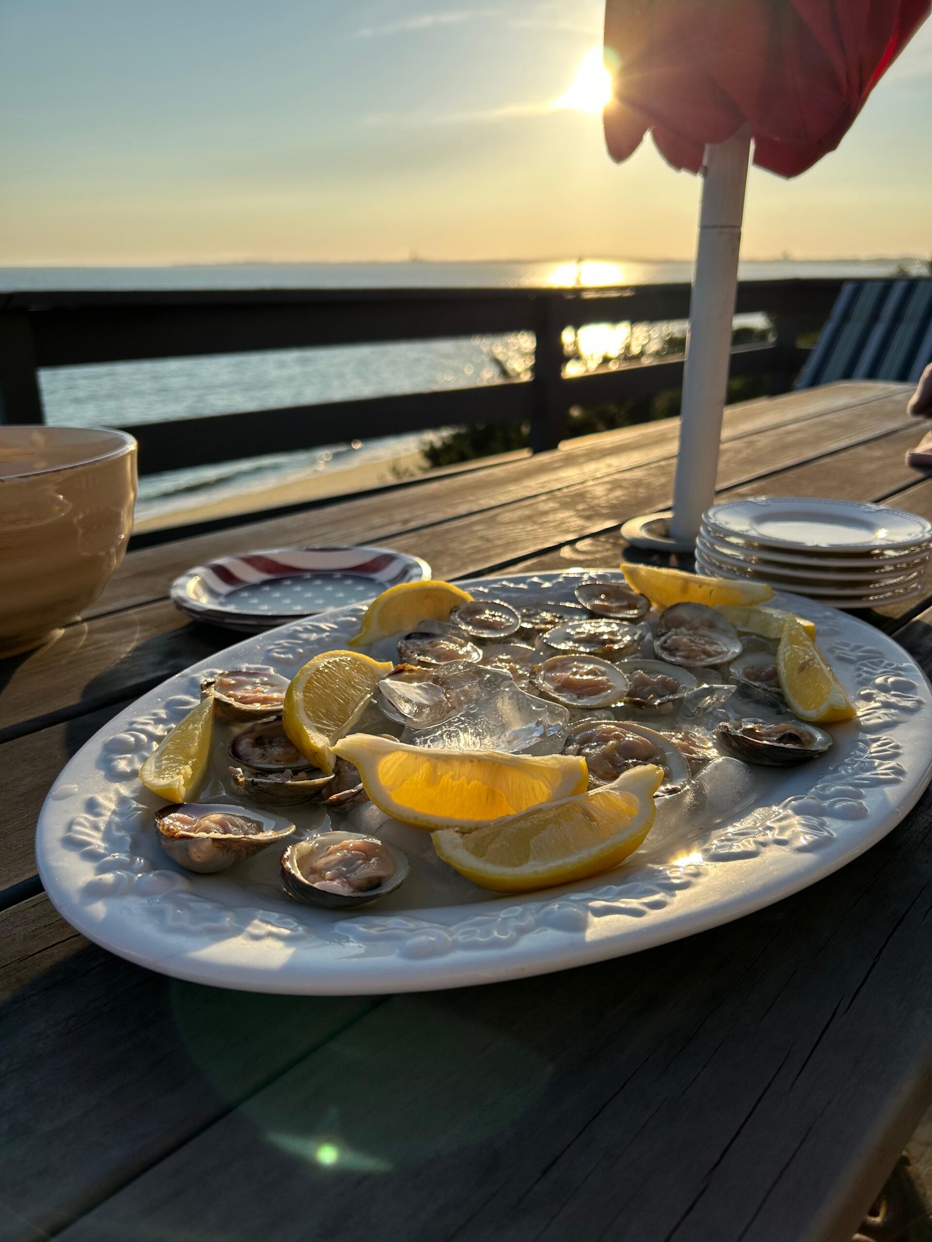 oysters and lemons on ice on a deck at sunset