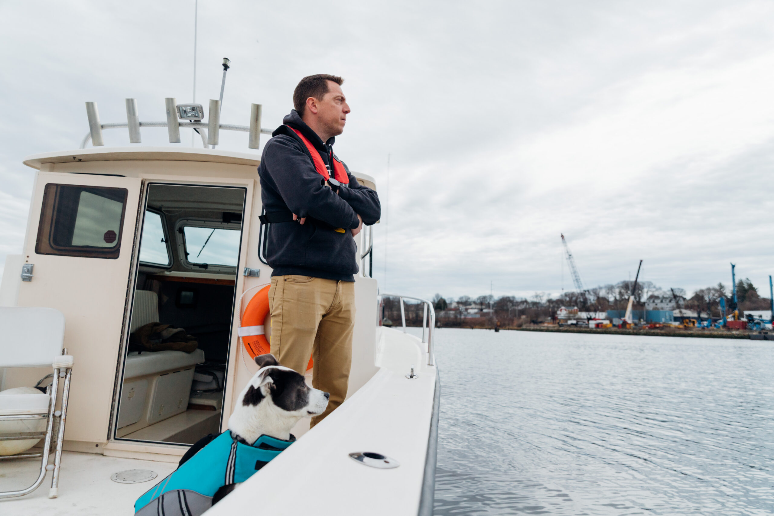 chris dodge narragansett baykeeper on boat with dog Naia