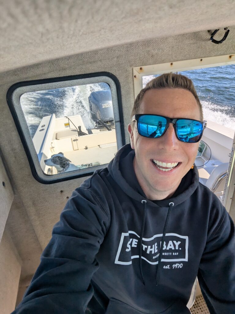 chris dodge on boat with dog naia
